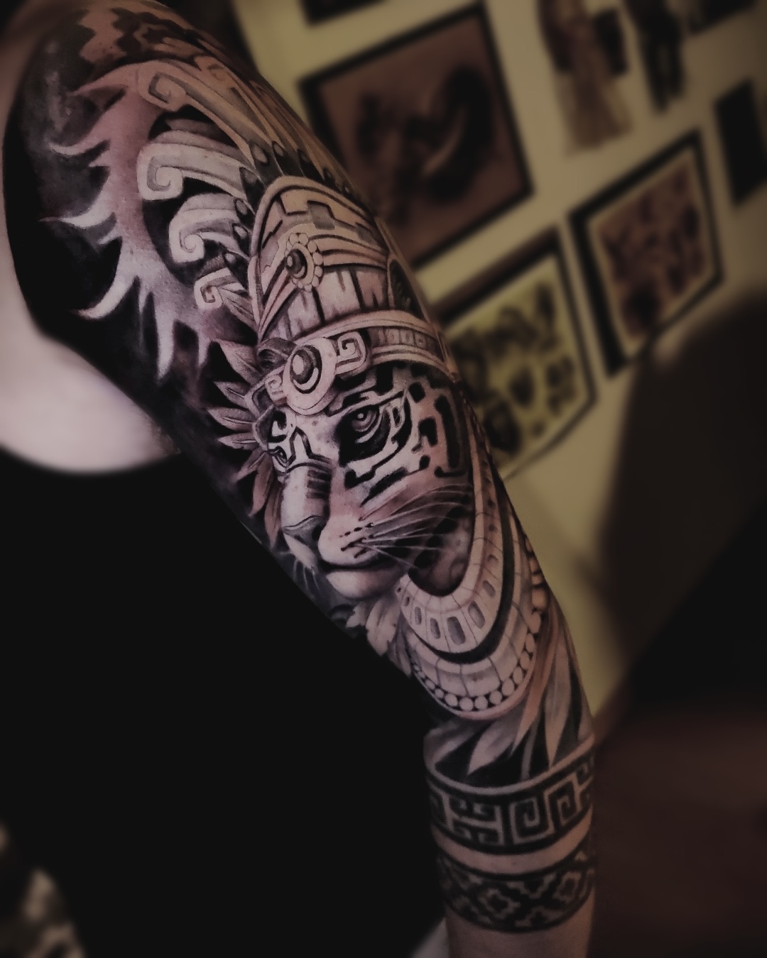 Tatouage réaliste noir et gris par NXO — sleeve Aztec détaillé