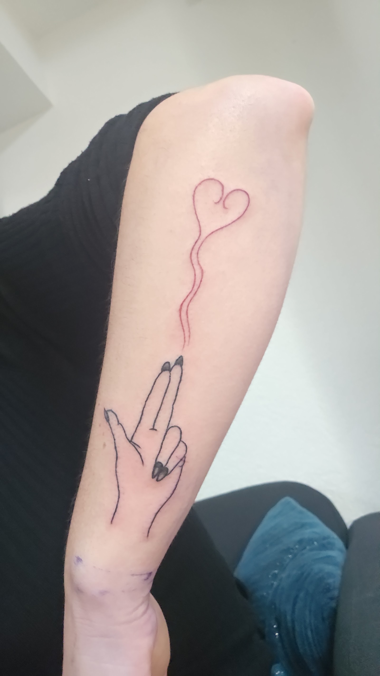 Tatouage fine line — main avec fil de coeur